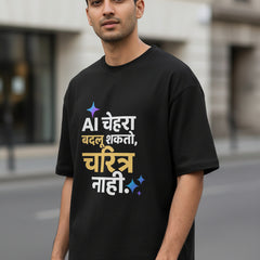 A black short-sleeve t-shirt with a colorful Hindi text graphic printed on the front, displayed against a light gray background.