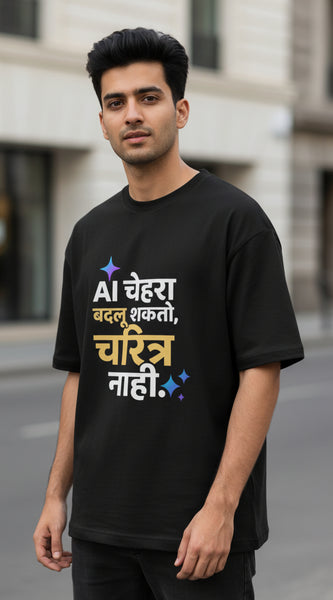 A black short-sleeve t-shirt with a colorful Hindi text graphic printed on the front, displayed against a light gray background.