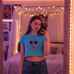 Woman wearing a blue t-shirt with sunglasses and lipstick graphic and denim shorts on a white background
