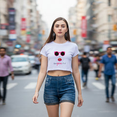 Woman wearing a light purple t-shirt with sunglasses and lipstick graphic, and blue denim shorts on a white background.