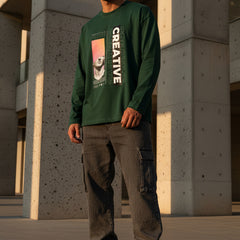 Green long-sleeve shirt with artistic design and 'CREATIVE' text on a white background