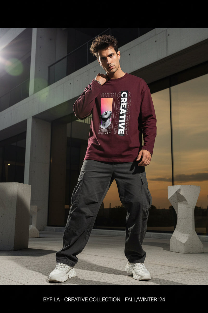 Maroon long-sleeve shirt with artistic design and 'CREATIVE' text on a white background