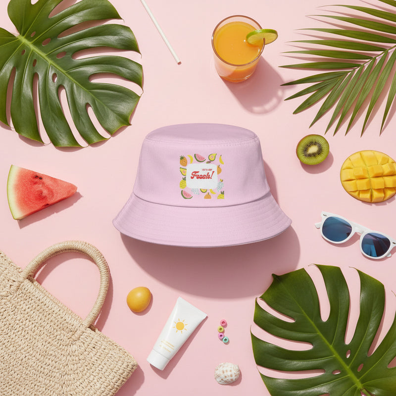 Pink bucket hat with fruit-themed design and text on a white background
