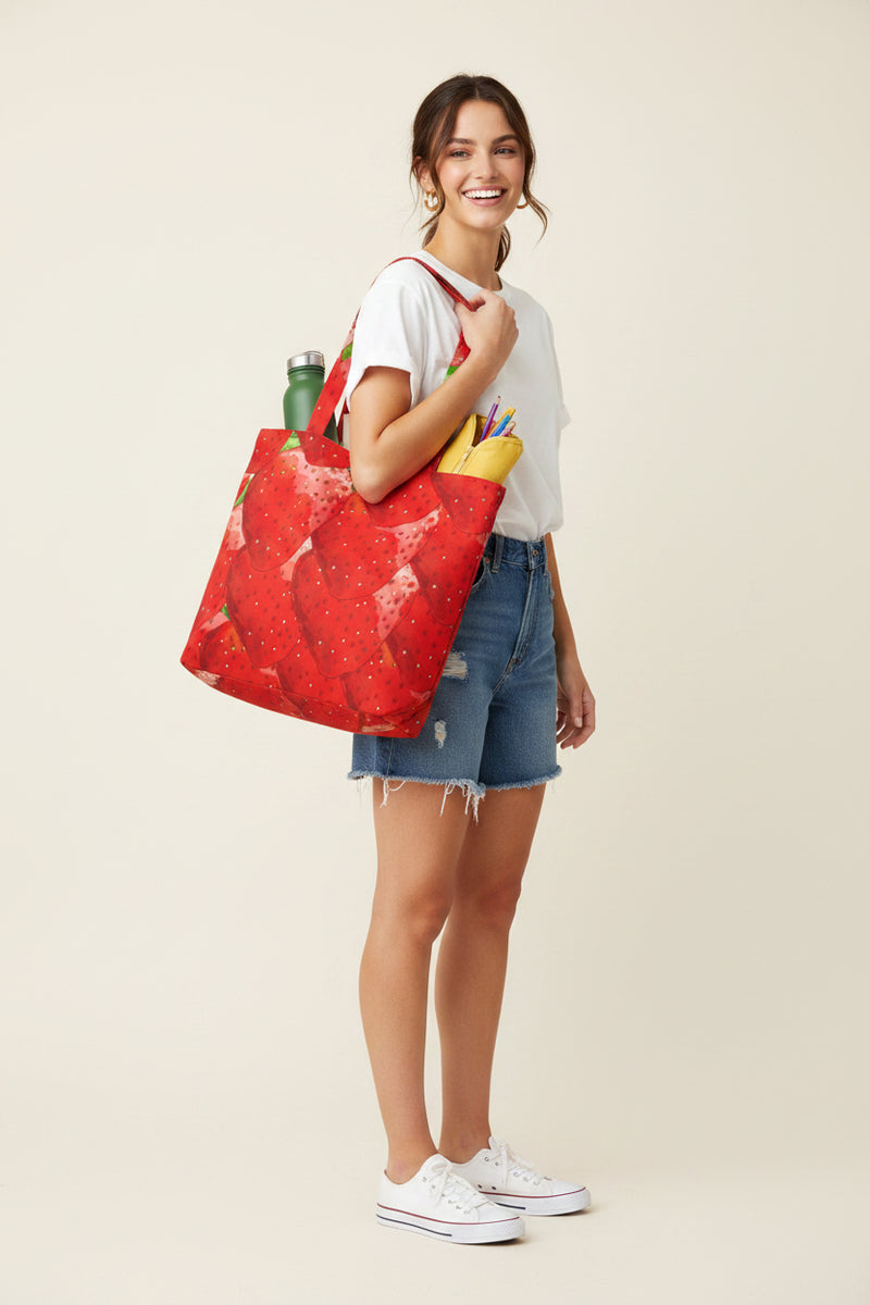 Tote bag with strawberry pattern filled with groceries on a white background