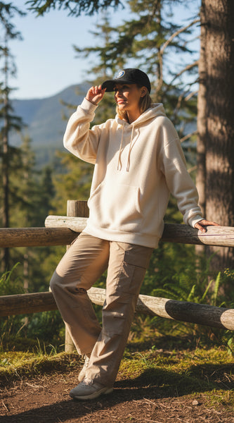 Black cap with 'Adventure into the Wild' logo on a light gray background
