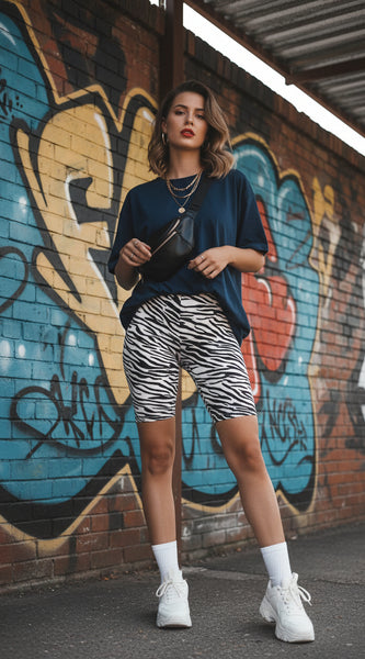 Person wearing zebra print shorts and a blue top, holding a soccer ball.