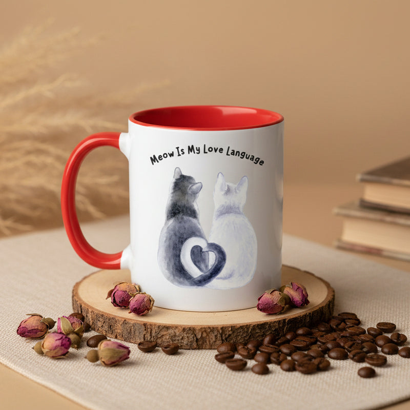 Two mugs with red handles on a pink background, one featuring a cat illustration and text.
