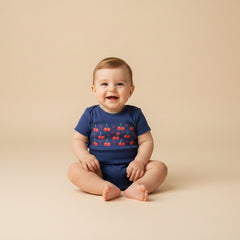 Navy blue baby onesie with red cherry design and text on a white background
