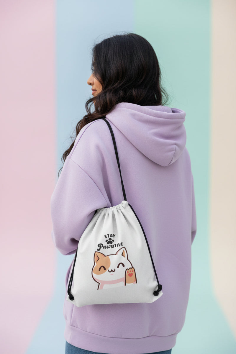 Drawstring bag with a cat illustration and 'Stay Pawsitive' text on a light background