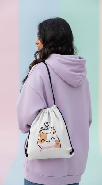 Drawstring bag with a cat illustration and 'Stay Pawsitive' text on a light background