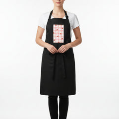 Woman wearing a black apron with a red and white pattern on a white background
