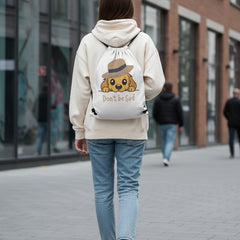 Drawstring bag with a cartoon dog wearing a hat and the text 'Don't be Sad' on a gray background.