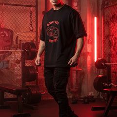 Black t-shirt with red graphic and text on a white background