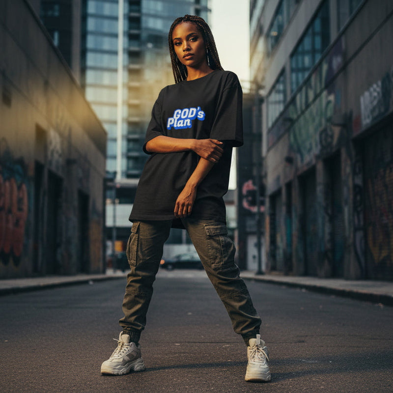 Women wearing a black t-shirt with 'GOD's Plan' text in an urban setting