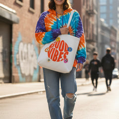 Tote bag with 'Good Vibes' design, filled with items on a white background