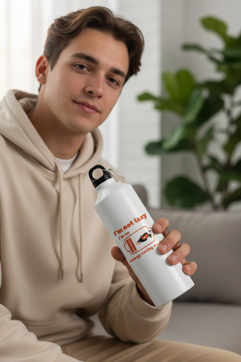 White water bottle with humorous design and text on a blurred green outdoor background