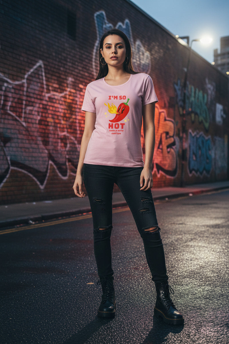 Woman wearing a pink t-shirt with a red pepper graphic and text.