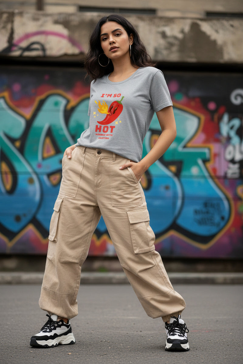 Woman wearing a gray t-shirt with a red pepper graphic and text.