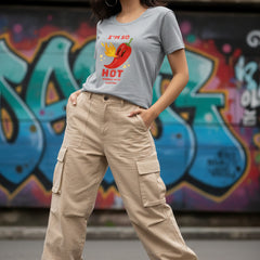 Woman wearing a gray t-shirt with a red pepper graphic and text.