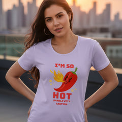 Woman wearing a light purple t-shirt with a red pepper graphic and text.