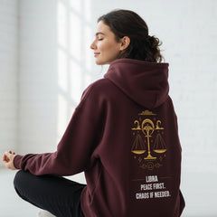 Maroon hoodie with gold Libra zodiac design and text on a white background