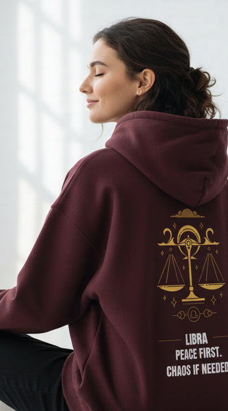 Maroon hoodie with gold Libra zodiac design and text on a white background