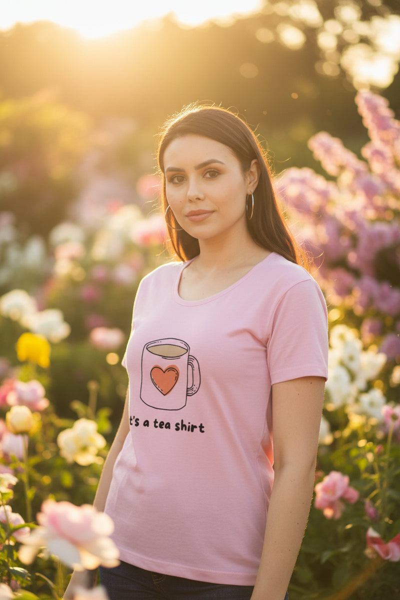Woman wearing a baby pink t-shirt with a coffee cup graphic and text on a white background