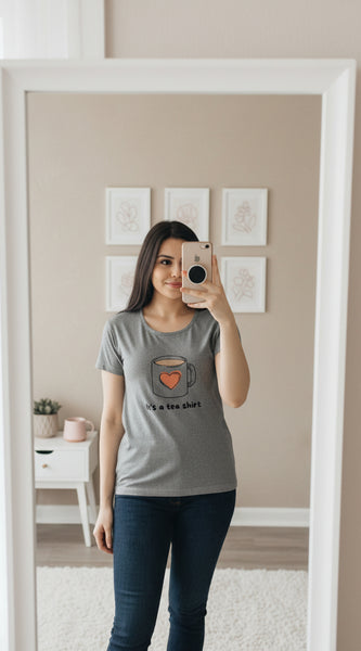 Woman wearing a gray t-shirt with a coffee mug graphic and text.