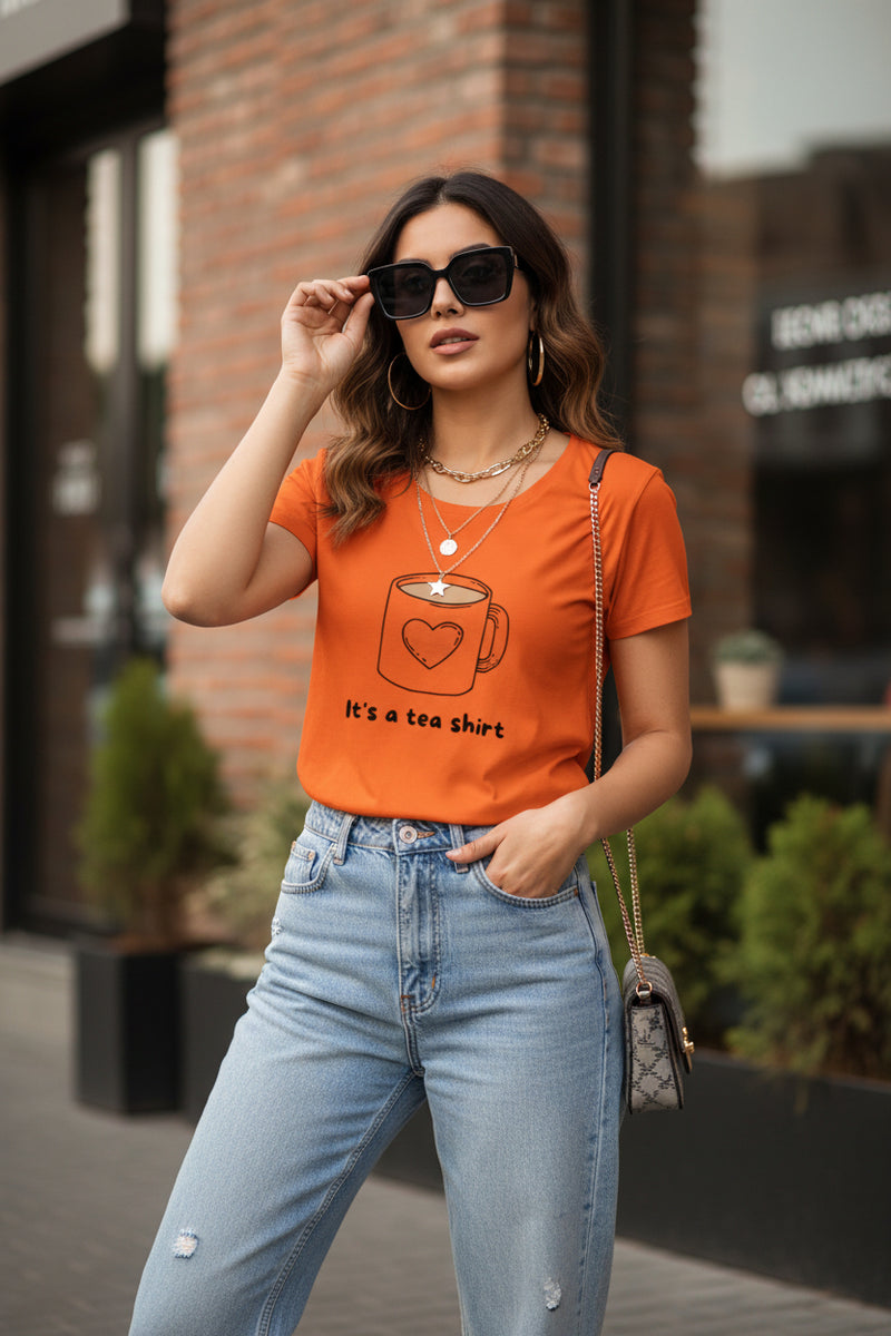 Woman wearing an orange t-shirt with a coffee cup graphic and text.