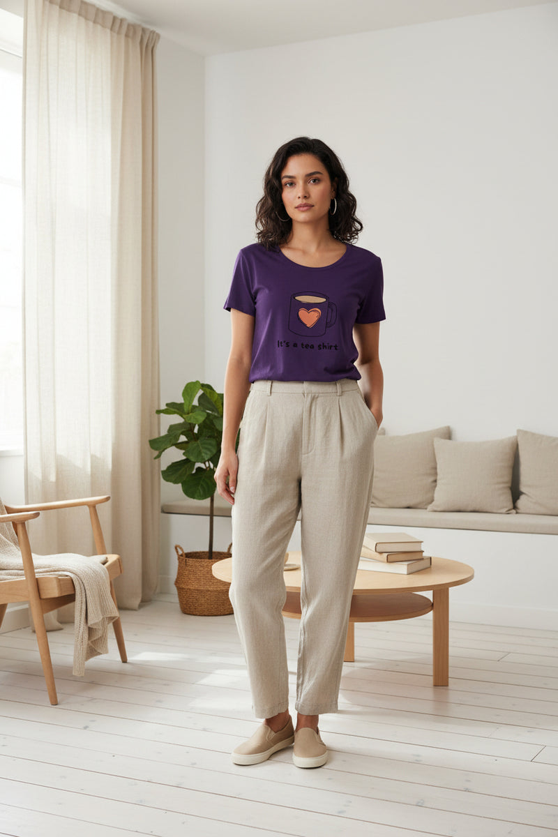Woman wearing a purple t-shirt with a graphic of a teacup and text on a white background