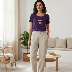 Woman wearing a purple t-shirt with a graphic of a teacup and text on a white background