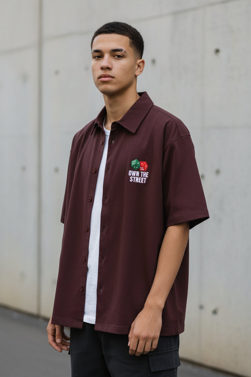 Maroon shirt with graphic design and text on a white background