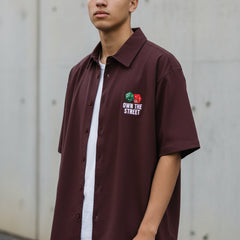 Maroon shirt with graphic design and text on a white background