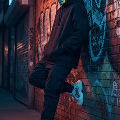 Person wearing a colorful balaclava with black spots on a white background