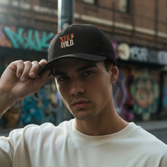 Black cap with 'Stay Wild' text on a light gray background