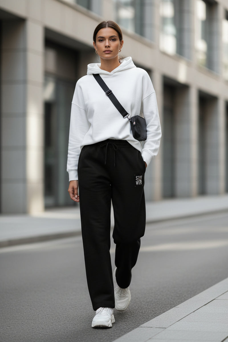 Black pants with a small embroidered design on a white background