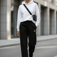 Black pants with a small embroidered design on a white background