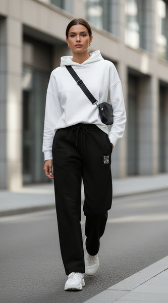 Black pants with a small embroidered design on a white background