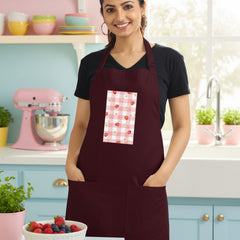 Woman wearing a maroon apron with a patterned pocket on a white background