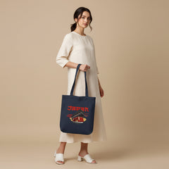 Navy tote bag with Japanese temple design and 'Japan' text held by a person against a gray background