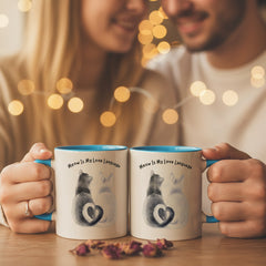 Two mugs with blue handles on a pink background, one featuring a cat illustration and text.